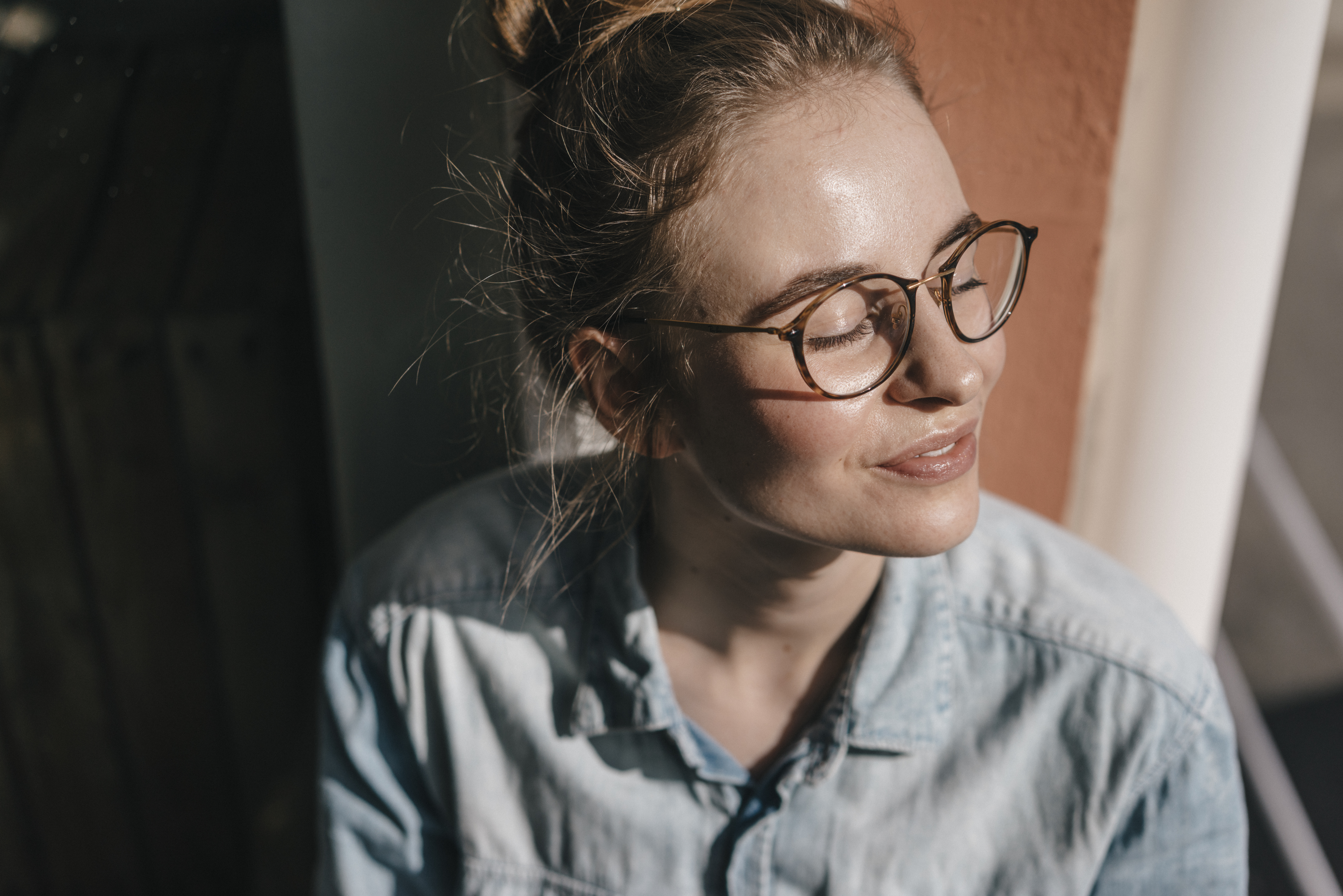 Woman wearing glasses looking towards the sun with eyes closed.jpg
